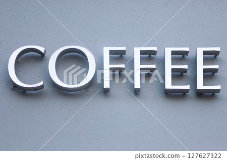 Metal sign COFFEE on the wall of the building 127627322