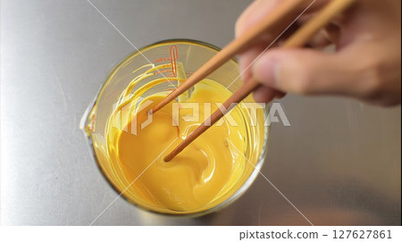 Hands mixing eggs 127627861