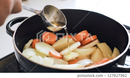 Putting seasoning into the pot 127627862