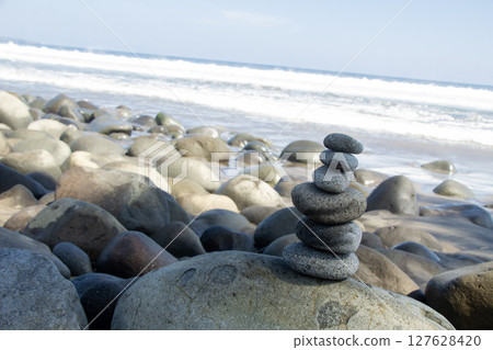 angle of shot and negative space Zen Stone Balance on Rocky Beach and ocean waves angle of shot and negative space Zen Stone Balance on Rocky Beach and ocean waves 127628420