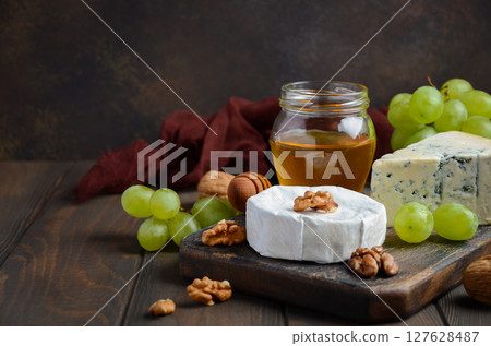 Variety of cheese with grapes, walnuts and honey. Selective focus, copy space. 127628487