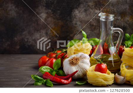 Pasta, vegetables, herbs and spices for Italian food on the wooden background, selective focus, copy space. 127628500