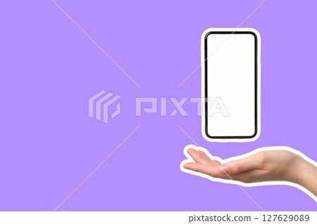 A hand holds a smartphone in mid-air against a bright purple backdrop A hand holds a smartphone in mid-air against a bright purple backdrop 127629089