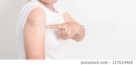 Elderly Woman with bandage after received vaccine. Vaccination and Immunization for Influenza, Herpes Zoster, Tetanus, Covid 19 booster, Dengue, Encephalitis, Rabies, Pneumococcal, IPD, RSV Vaccines 127629489