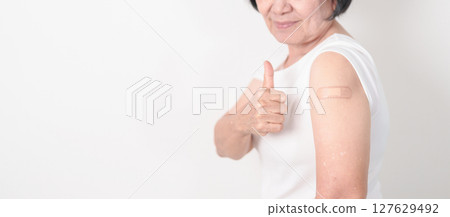 Elderly Woman with bandage after received vaccine. Vaccination and Immunization for Influenza, Herpes Zoster, Tetanus, Covid 19 booster, Dengue, Encephalitis, Rabies, Pneumococcal, IPD, RSV Vaccines 127629492
