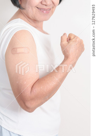 Elderly Woman with bandage after received vaccine. Vaccination and Immunization for Influenza, Herpes Zoster, Tetanus, Covid 19 booster, Dengue, Encephalitis, Rabies, Pneumococcal, IPD, RSV Vaccines 127629493