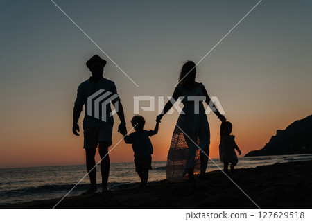 Parents with small children enjoying summer evening by the sea 127629518