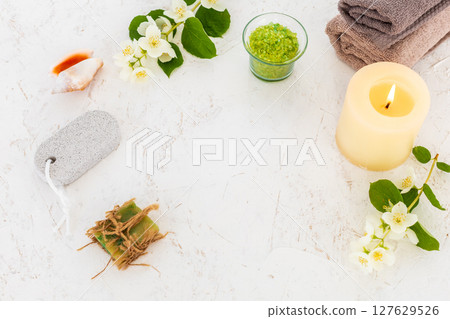 Towels with body care products and branches of jasmine on the white background. 127629526