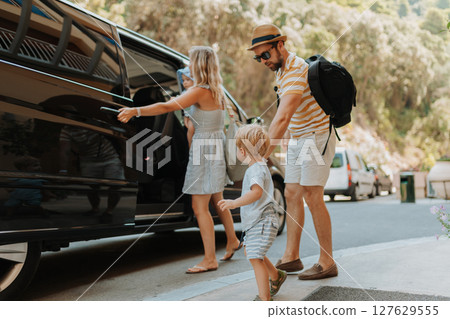 Parents with toddlers boarding car for airport transfer or holiday trip 127629555