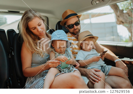 Family road trip with kids in backseat of vehicle 127629556