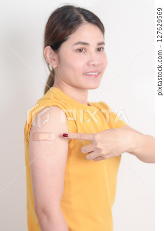 Adult Woman with bandage after received vaccine. Vaccination and Immunization for Influenza, HPV, Zoster, IPD, DTP or Diphtheria, Tetanus and Pertussis, MMR, Hepatitis B, Covid and Varicella vaccine 127629569