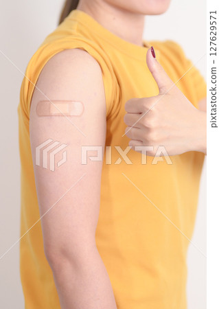 Adult Woman with bandage after received vaccine. Vaccination and Immunization for Influenza, HPV, Zoster, IPD, DTP or Diphtheria, Tetanus and Pertussis, MMR, Hepatitis B, Covid and Varicella vaccine 127629571