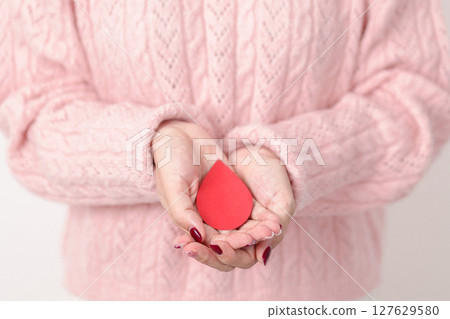 Adult woman with red Blood drop paper for concept of June World Blood Donor day, Donation, April Hemophilia awareness day, May Thalassemia Day, Anemia awareness, June Sickle Cell and Blood Disorders 127629580