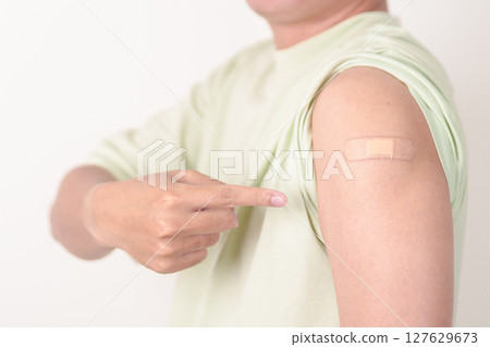 Adult Man with bandage after received vaccine. Vaccination and Immunization for Influenza, HPV, Zoster, IPD, DTP or Diphtheria, Tetanus and Pertussis, MMR, Hepatitis B, Covid and Varicella vaccine 127629673
