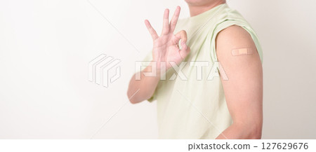 Adult Man with bandage after received vaccine. Vaccination and Immunization for Influenza, HPV, Zoster, IPD, DTP or Diphtheria, Tetanus and Pertussis, MMR, Hepatitis B, Covid and Varicella vaccine 127629676