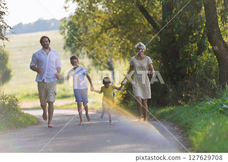 A family with small children running barefoot on a road in summer. A family with small children running barefoot on a road in summer. 127629708