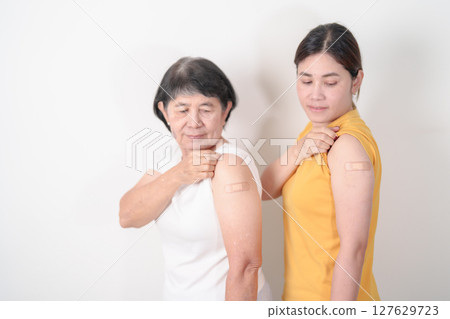 Adult and Elderly Woman with bandage after received vaccine. Vaccination and Immunization for Influenza, HPV, Zoster, IPD, DTP, Dengue, Encephalitis, Rabies, Pneumococcal Hepatitis B and Covid vaccine 127629723