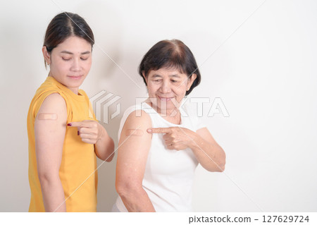 Adult and Elderly Woman with bandage after received vaccine. Vaccination and Immunization for Influenza, HPV, Zoster, IPD, DTP, Dengue, Encephalitis, Rabies, Pneumococcal Hepatitis B and Covid vaccine 127629724