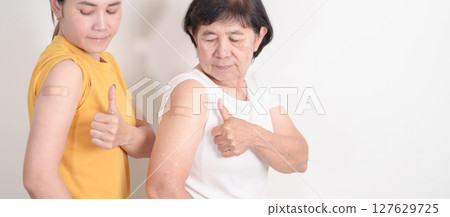 Adult and Elderly Woman with bandage after received vaccine. Vaccination and Immunization for Influenza, HPV, Zoster, IPD, DTP, Dengue, Encephalitis, Rabies, Pneumococcal Hepatitis B and Covid vaccine Adult and Elderly Woman with bandage after received vaccine. Vaccination and Immunization for Influenza, HPV, Zoster, IPD, DTP, Dengue, Encephalitis, Rabies, Pneumococcal Hepatitis B and Covid vaccine 127629725