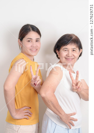 Adult and Elderly Woman with bandage after received vaccine. Vaccination and Immunization for Influenza, HPV, Zoster, IPD, DTP, Dengue, Encephalitis, Rabies, Pneumococcal Hepatitis B and Covid vaccine 127629731