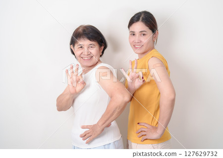 Adult and Elderly Woman with bandage after received vaccine. Vaccination and Immunization for Influenza, HPV, Zoster, IPD, DTP, Dengue, Encephalitis, Rabies, Pneumococcal Hepatitis B and Covid vaccine 127629732