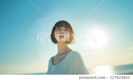 一個女人抬頭望著夕陽的天空 127629843