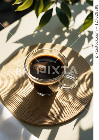 cup of coffee. Coffee on Table with Sunlight and foliage 127629899