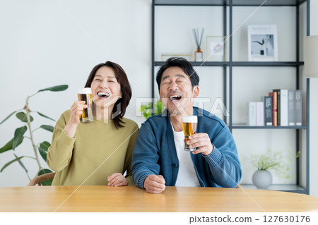 Middle-aged couple drinking beer at home 127630176