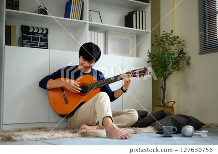 young musician playing acoustic on carpet. 127630756
