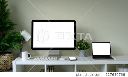 Modern workspace with desktop computer, digital tablet, and smartphone on a white desk Modern workspace with desktop computer, digital tablet, and smartphone on a white desk 127630766