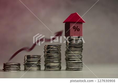 Stacked coins with house and percentage symbol representing mortgage interest rates and real estate investment Stacked coins with house and percentage symbol representing mortgage interest rates and real estate investment 127630908