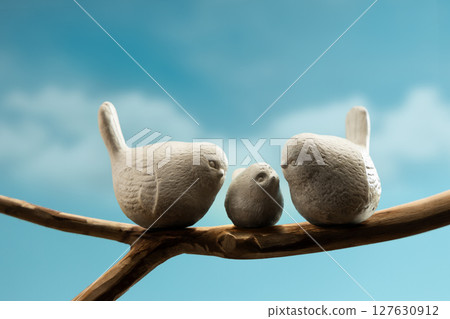 Mother, Father and baby birds perched on branch, symbolizing family love, care, and emotional bonding in nature 127630912