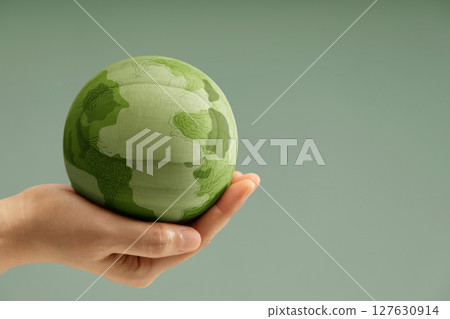Green earth held gently in hands, symbolizing environmental conservation, care for the planet, and sustainability. Side view with copy space Green earth held gently in hands, symbolizing environmental conservation, care for the planet, and sustainability. Side view with copy space 127630914