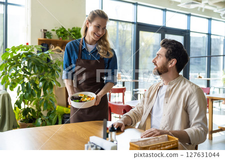 Waitress getting an order to the client in pizzeria 127631044