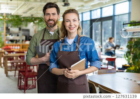 Two waiters in pizzeria looking happy and confident wile waiting for the clients 127631139