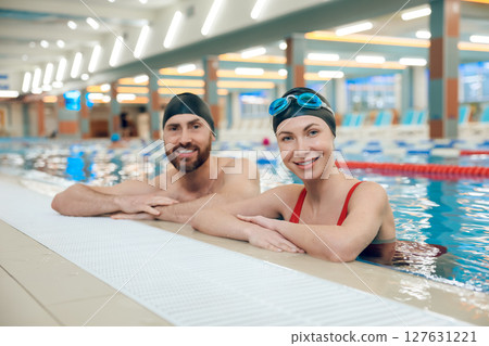 Young cute couple in swimwear in the swimming pool looking enjoyed 127631221