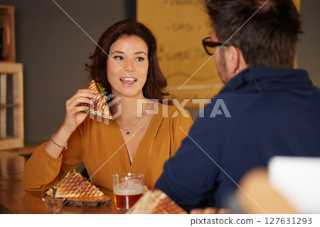 Young woman eat a club sandwich in a bar 127631293