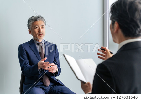 Middle-aged male business person being interviewed Middle-aged male business person being interviewed 127631540