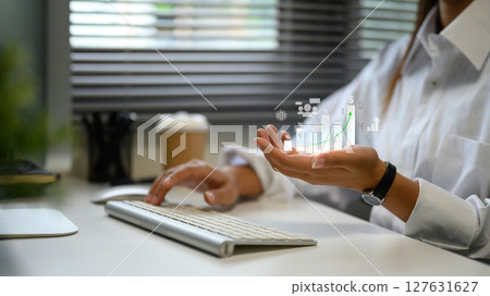 Concept of financial analytics with digital bar graph and statistics hovering over hand 127631627