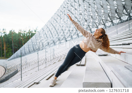 Athletic young woman training outdoors. Fitness woman stretching outdoors. Active lifestyle. 127631718
