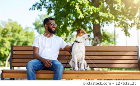 Happy young couple and their dog enjoying a summer day sitting on a park bench Happy young couple and their dog enjoying a summer day sitting on a park bench 127632125