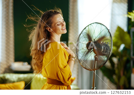 Serene Woman Enjoying Fan\'s Rotating Breeze Serene Woman Enjoying Fan\'s Rotating Breeze 127632153
