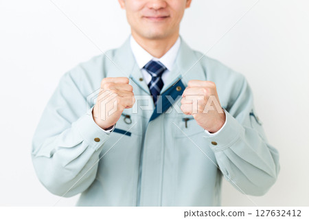 一位身穿綠色工作服、揮拳的中年男性商人 一位身穿綠色工作服、揮拳的中年男性商人 127632412