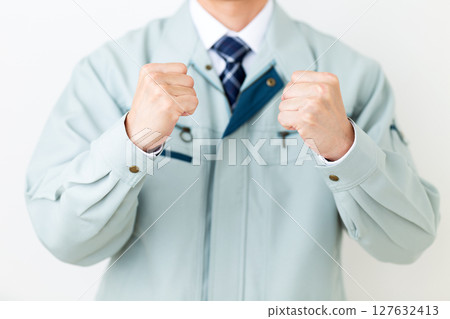 一位身穿綠色工作服、揮拳的中年男性商人 127632413