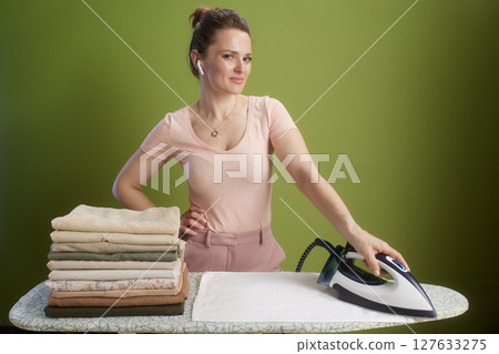 Ironing day: Calm smile, neat clothes, muted green background 127633275