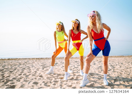 Young dancers in colorful swimsuits are dancing in morning. ?oncept of sports, fitness Active sport. 127634164