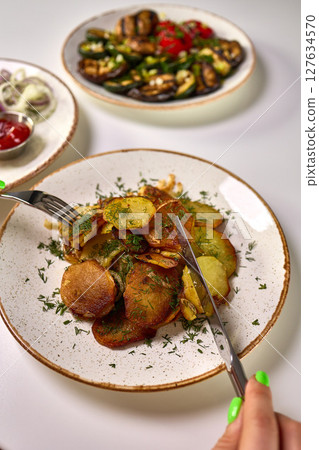 Fried Sliced Potatoes with Fresh Dill Garnish 127634570