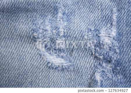 Closeup detail of torn on blue jeans. Denim jeans texture. Closeup detail of torn on blue jeans. Denim jeans texture. 127634927