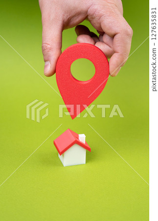 New place of residence. Hand with geolocation button points to the house. Depicts home search 127635831