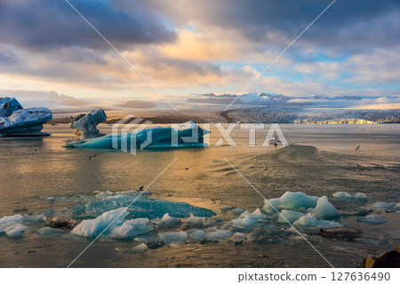 Ice Lagoon. Icebergs floating in Jokulsarlon glacier lagoon lake at sunset. South Iceland, Jokulsarlon Ice Waterfall. Great tourist attraction. 127636490
